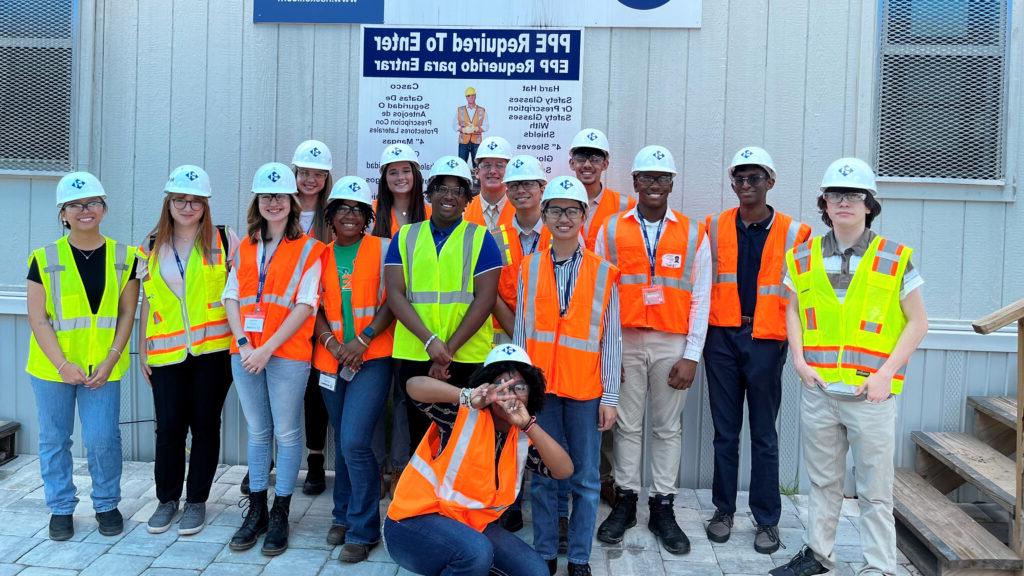 The 14 members of 澳门足彩app’s High School Internship Program, who visited five projects during the six-week curriculum, pose for a photo outside the jobsite trailer at the JEA H2.0 Purification project.